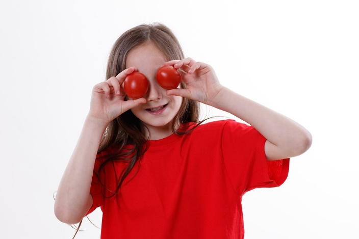 a girl holding fresh tomatoes