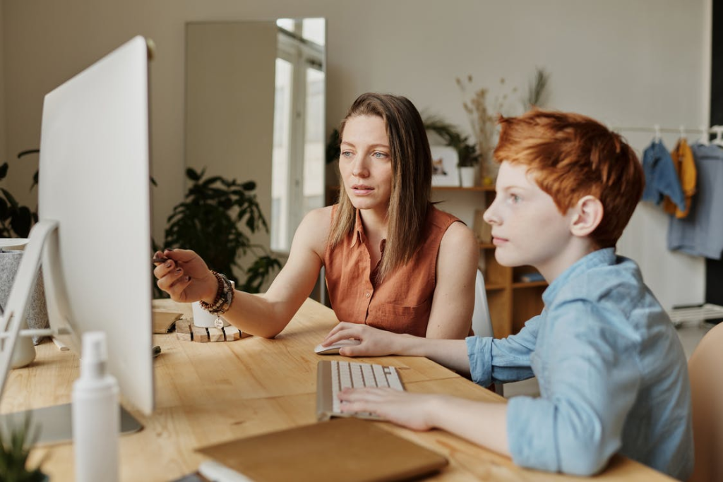 A mother helping her child with online tutoring 