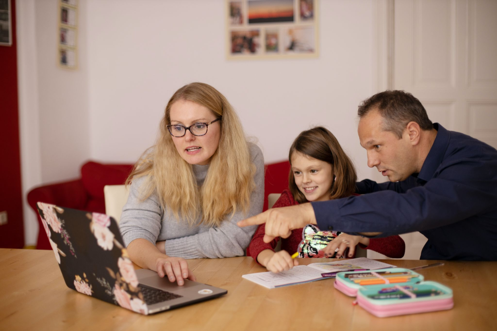 Parents helping their child with online learning