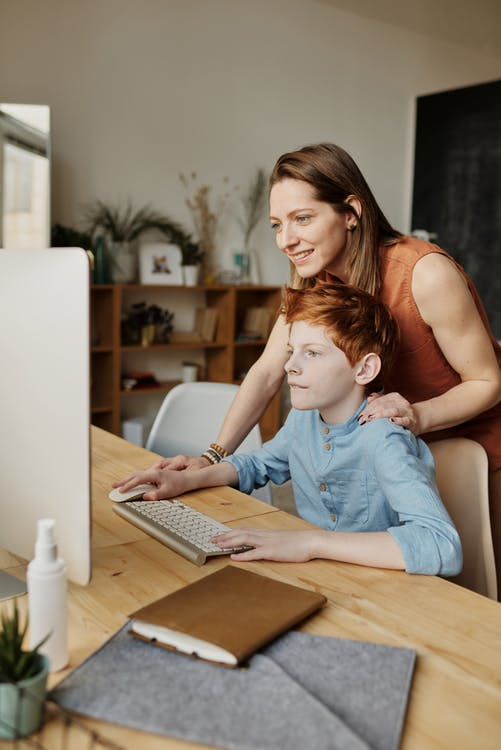 A parent assisting with an online tutoring session 